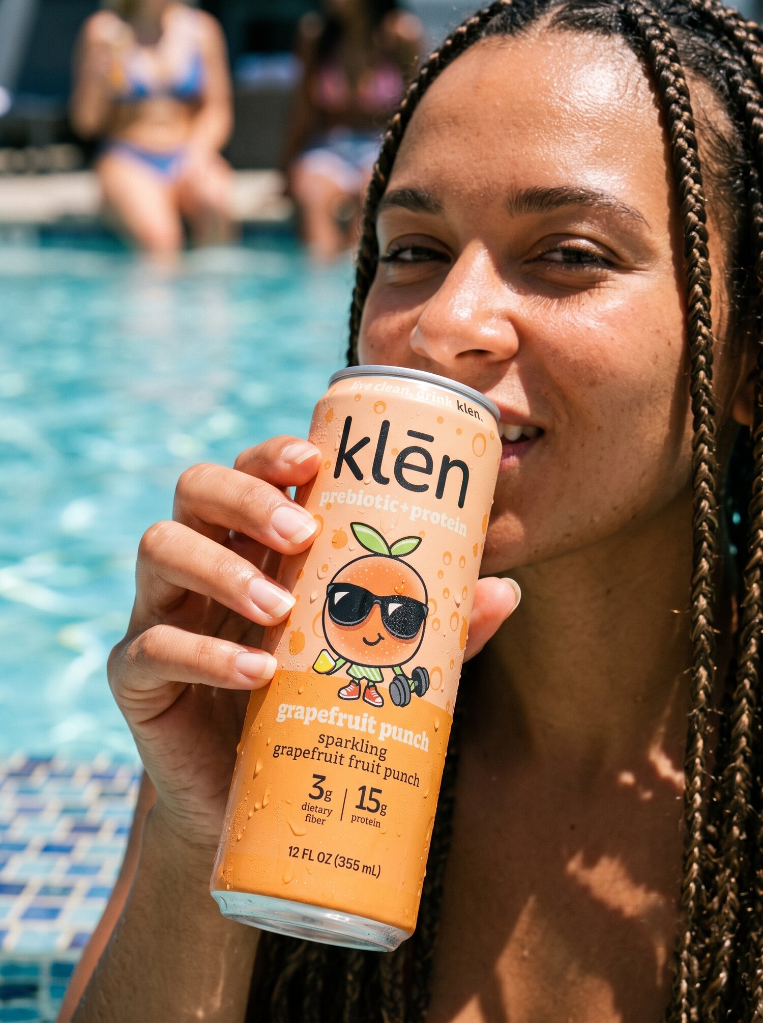 someone drinking a klēn grapefruit punch by the pool